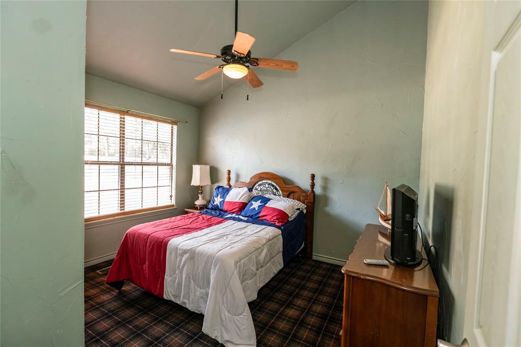 698 Storey Road Nocona, TX 76255 - Photo 18 of 34 Bedroom with dark carpet, vaulted ceiling, and ceiling fan