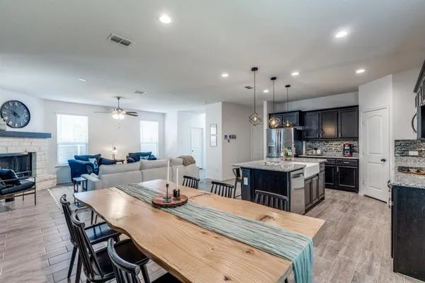 a large kitchen with kitchen island a dining table and chairs