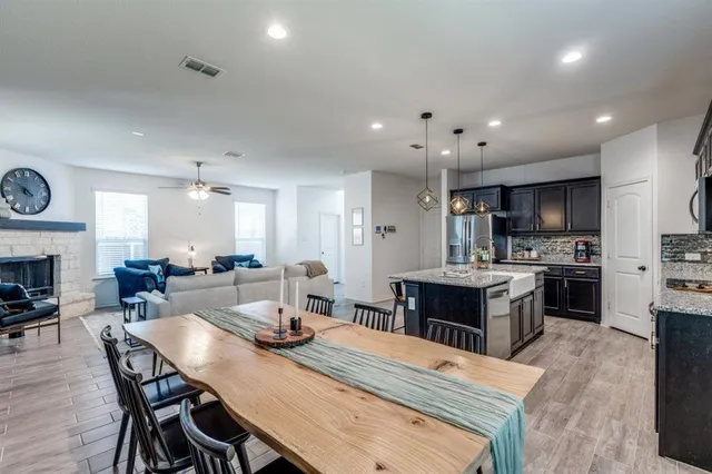 a large kitchen with kitchen island a dining table and chairs