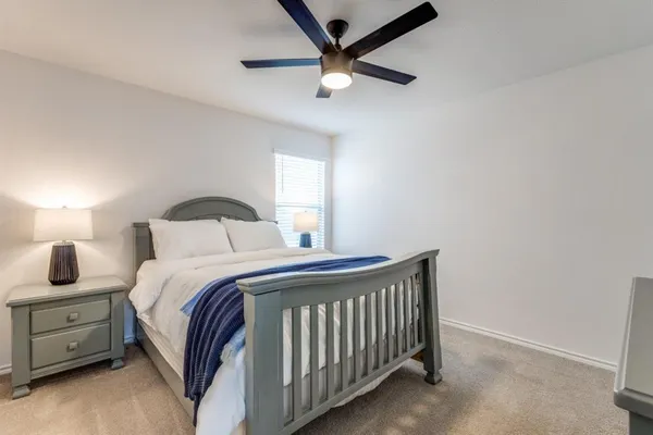 a bedroom with a bed and a ceiling fan