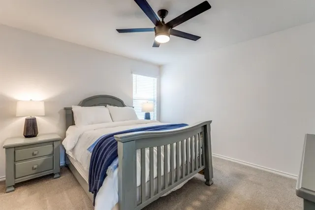 a bedroom with a bed and a ceiling fan
