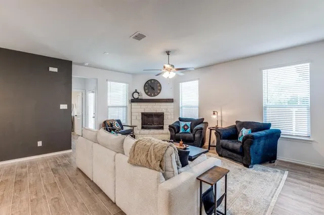 a living room with furniture a fireplace and a large window