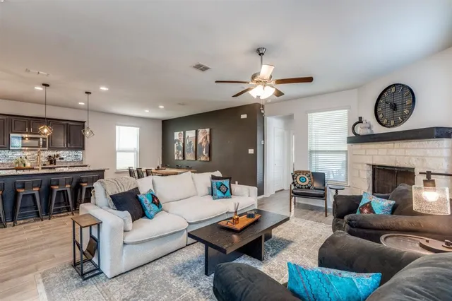 a living room with furniture a fireplace and a large window
