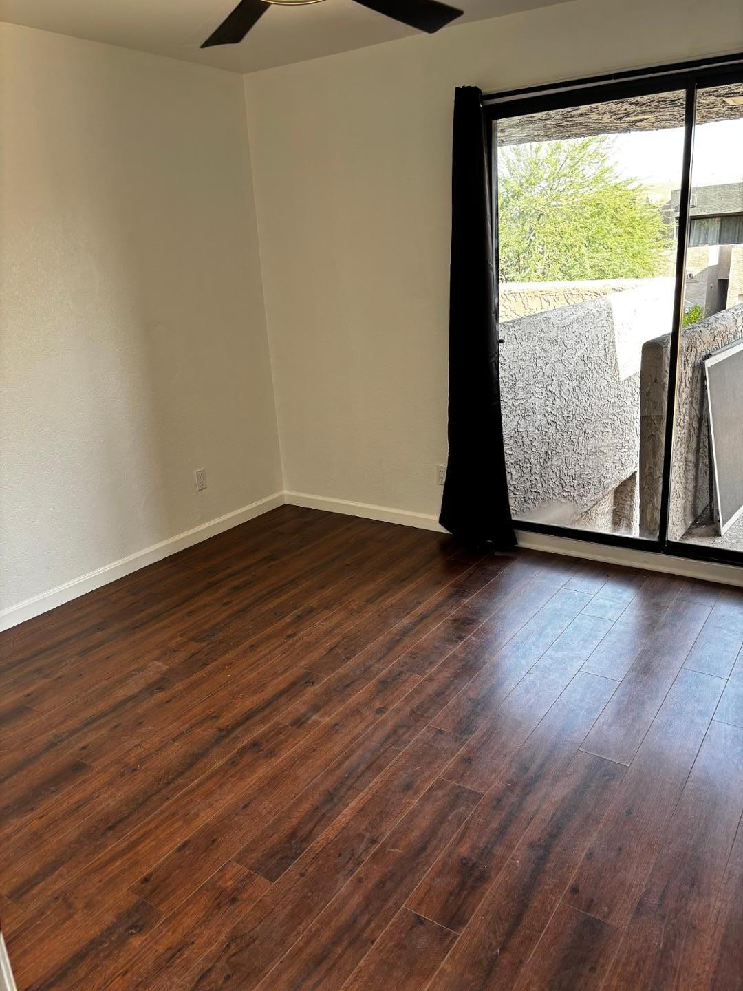 3030 North Hayden Road, Unit 16 Scottsdale, AZ 85251 - Photo 17 of 30 a view of an empty room with wooden floor and a window