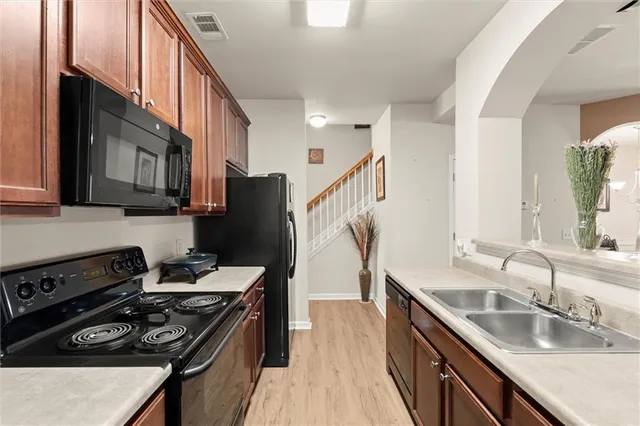 a kitchen with stainless steel appliances granite countertop a stove a sink dishwasher and a refrigerator