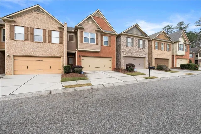 a view of a white house with large windows and a yard