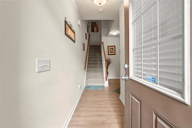 a view of a hallway with wooden floor and staircase