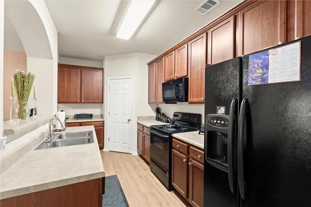 a kitchen with stainless steel appliances granite countertop a refrigerator stove microwave and sink