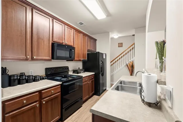 a kitchen with stainless steel appliances a stove a sink a microwave and cabinets
