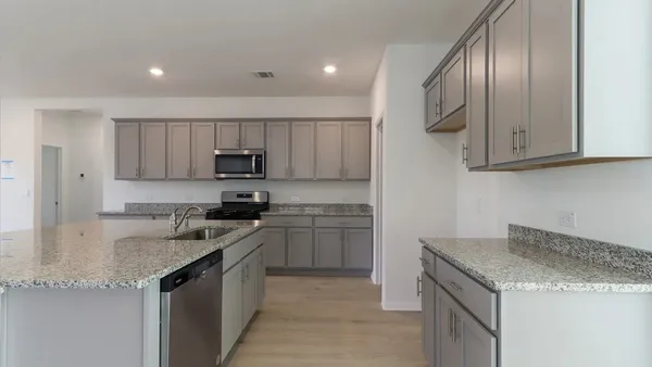 a kitchen with stainless steel appliances granite countertop a sink stove microwave and cabinets