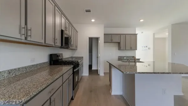 a kitchen with stainless steel appliances granite countertop a stove a sink and a refrigerator