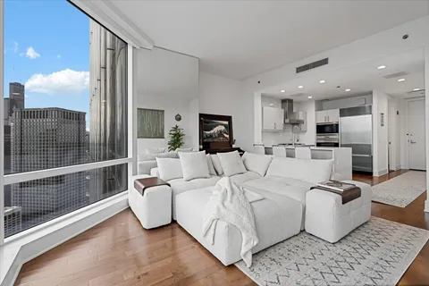 a large white kitchen with stainless steel appliances granite countertop a stove a sink and a refrigerator