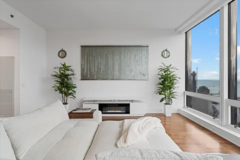 a living room with furniture kitchen view and a large window