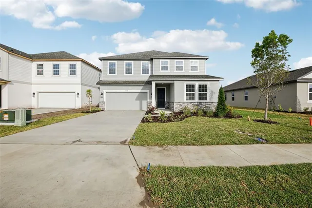 a front view of a house with a yard and garage