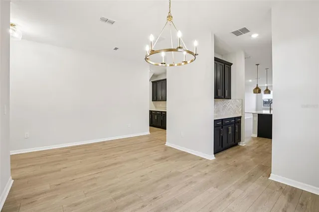 a large kitchen with stainless steel appliances kitchen island granite countertop a sink a stove and a wooden floors