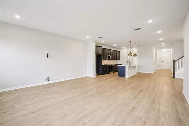 a view of empty room with wooden floor and windows