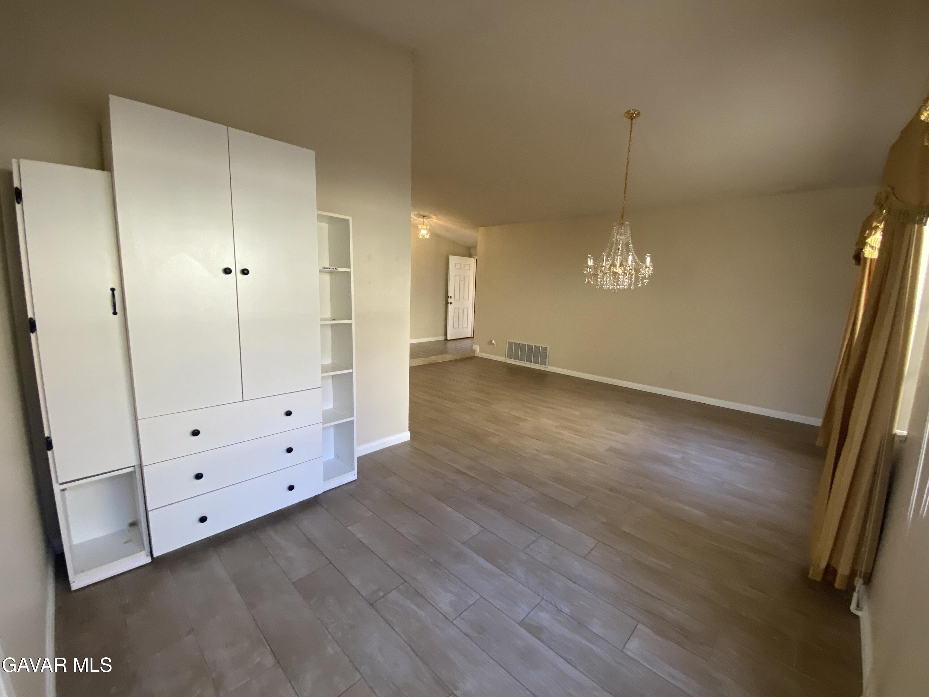 44034 4th Street East Lancaster, CA 93535 - Photo 7 of 14 an empty room with wooden floor and cabinet