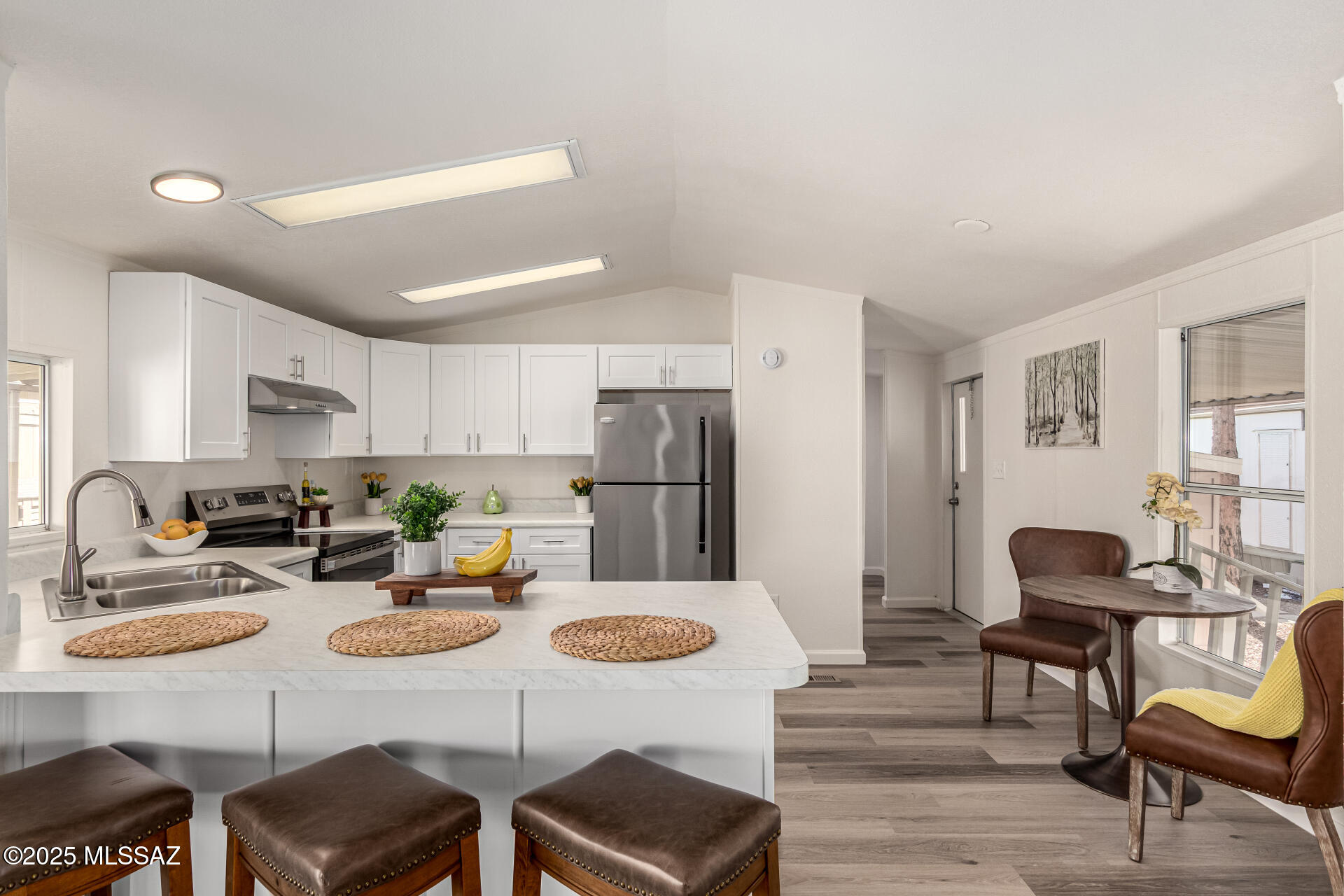8401 South Kolb Road, Unit 94 Tucson, AZ 85756 - Photo 11 of 24 a kitchen with stainless steel appliances kitchen island granite countertop a dining table chairs and refrigerator