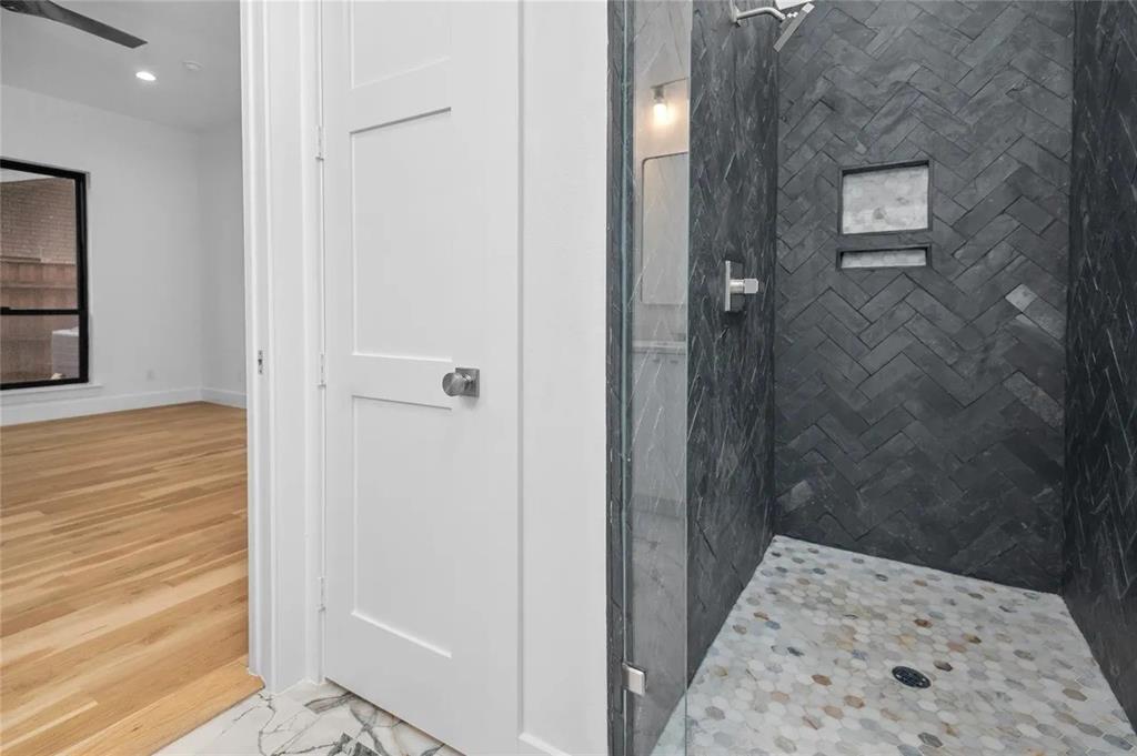 309 Kaye Street Coppell, TX 75019 - Photo 29 of 36 Walk-in shower featuring dark herringbone tile walls, an integrated niche, and a hexagonal tile floor