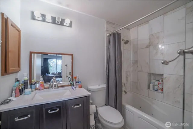 a bathroom with a granite countertop sink toilet and shower