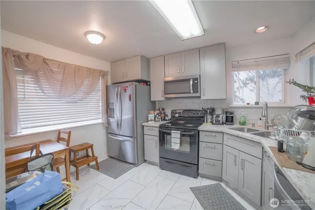 a kitchen with stainless steel appliances granite countertop a refrigerator sink and stove