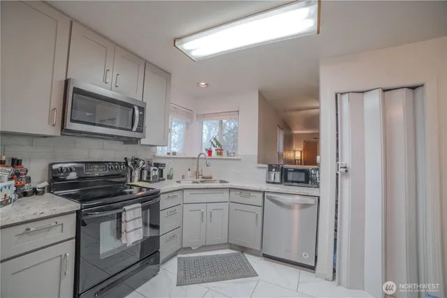 a kitchen with cabinets appliances a sink and a window
