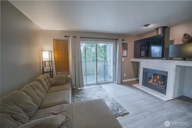 a living room with furniture a flat screen tv and a fireplace