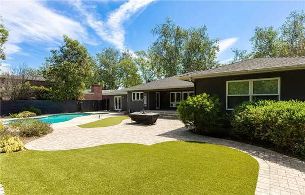 a view of a house with backyard and sitting area