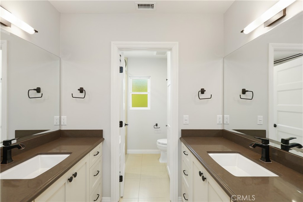 933 West Riviera Drive Santa Ana, CA 92706 - Photo 42 of 43 a bathroom with a sink vanity granite tub shower and a mirror
