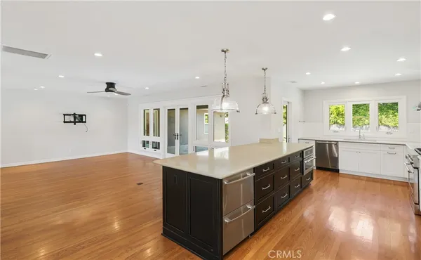 a kitchen with kitchen island a sink wooden floor and counter space