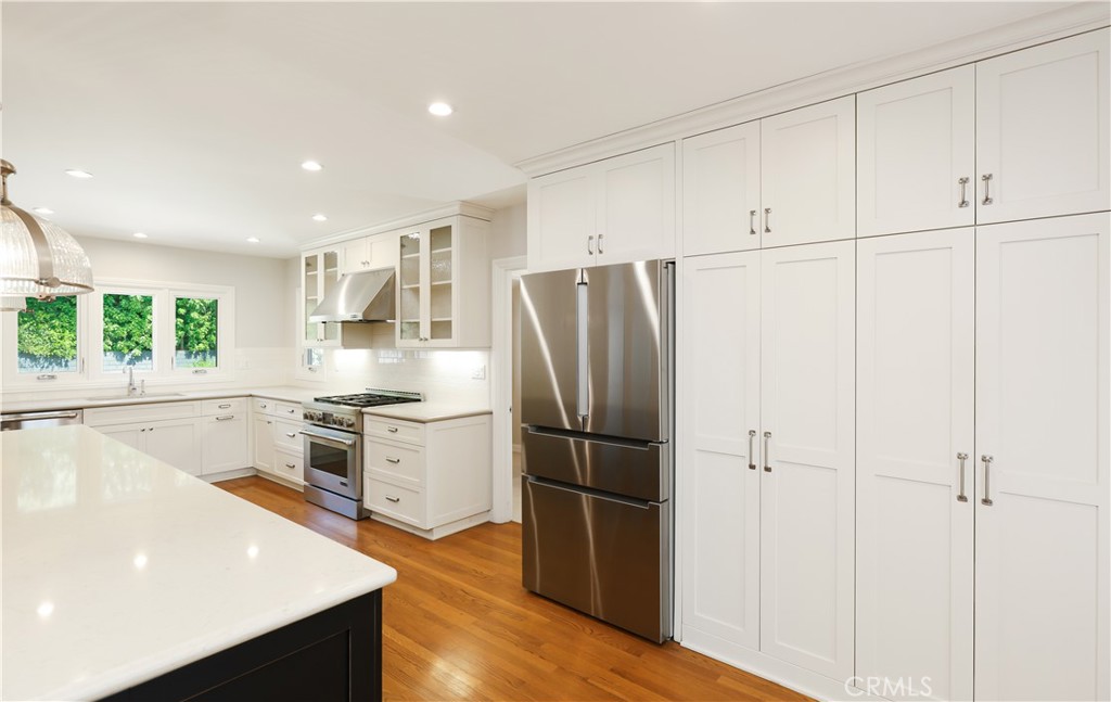 933 West Riviera Drive Santa Ana, CA 92706 - Photo 8 of 43 a kitchen with a refrigerator a stove cabinets and wooden floor