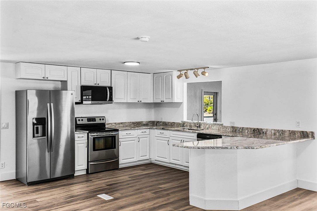 13651 Grackle Road Fort Myers, FL 33908 - Photo 2 of 43 a kitchen with stainless steel appliances granite countertop a stove a sink and a refrigerator
