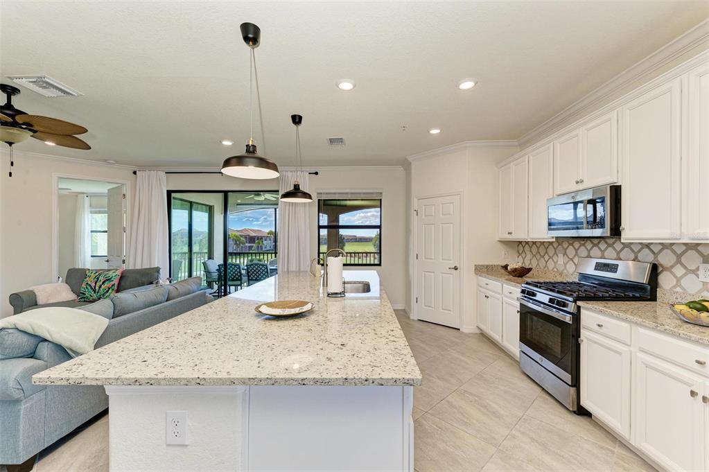 6086 Worsham Lane, Unit 103 Bradenton, FL 34211 - Photo 13 of 60 a kitchen with granite countertop kitchen island stainless steel appliances a sink and a counter top space