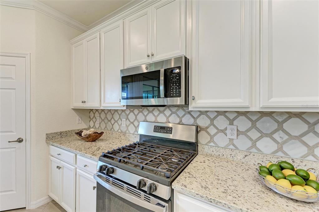 6086 Worsham Lane, Unit 103 Bradenton, FL 34211 - Photo 14 of 60 a kitchen with granite countertop white cabinets stainless steel appliances and a counter space