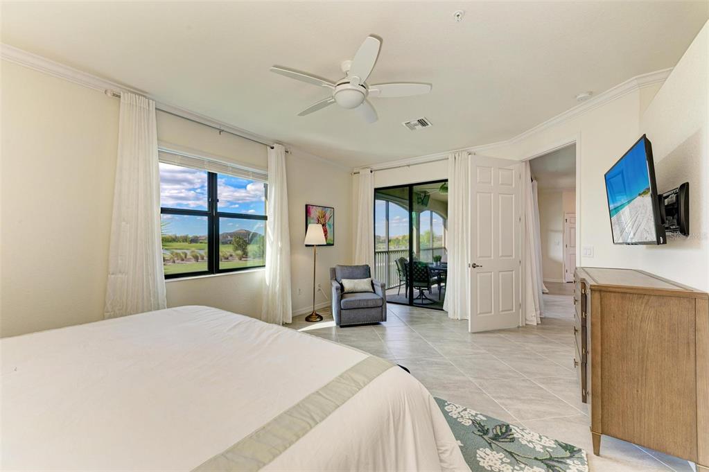 6086 Worsham Lane, Unit 103 Bradenton, FL 34211 - Photo 22 of 60 a bedroom with a large bed a flat tv screen and large window