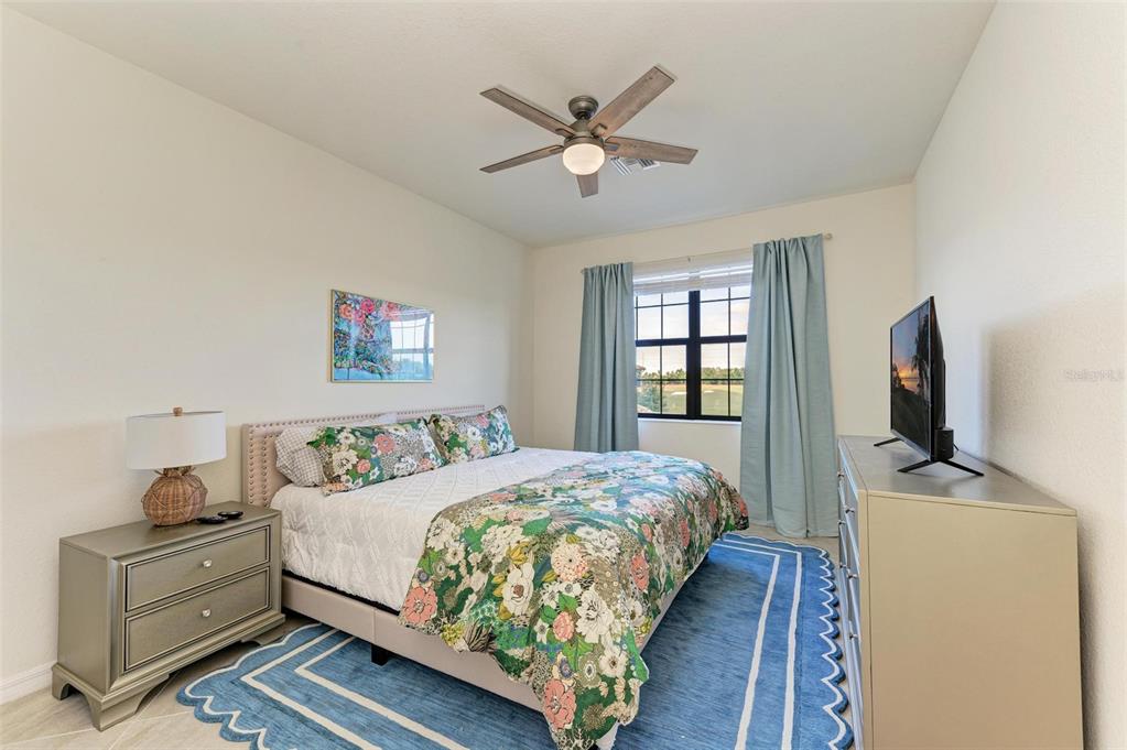 6086 Worsham Lane, Unit 103 Bradenton, FL 34211 - Photo 25 of 60 a bedroom with a bed and a flat screen tv
