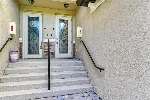 a view of staircase with white walls and a rug