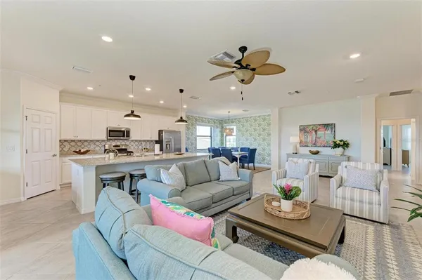a living room with furniture kitchen view and a chandelier