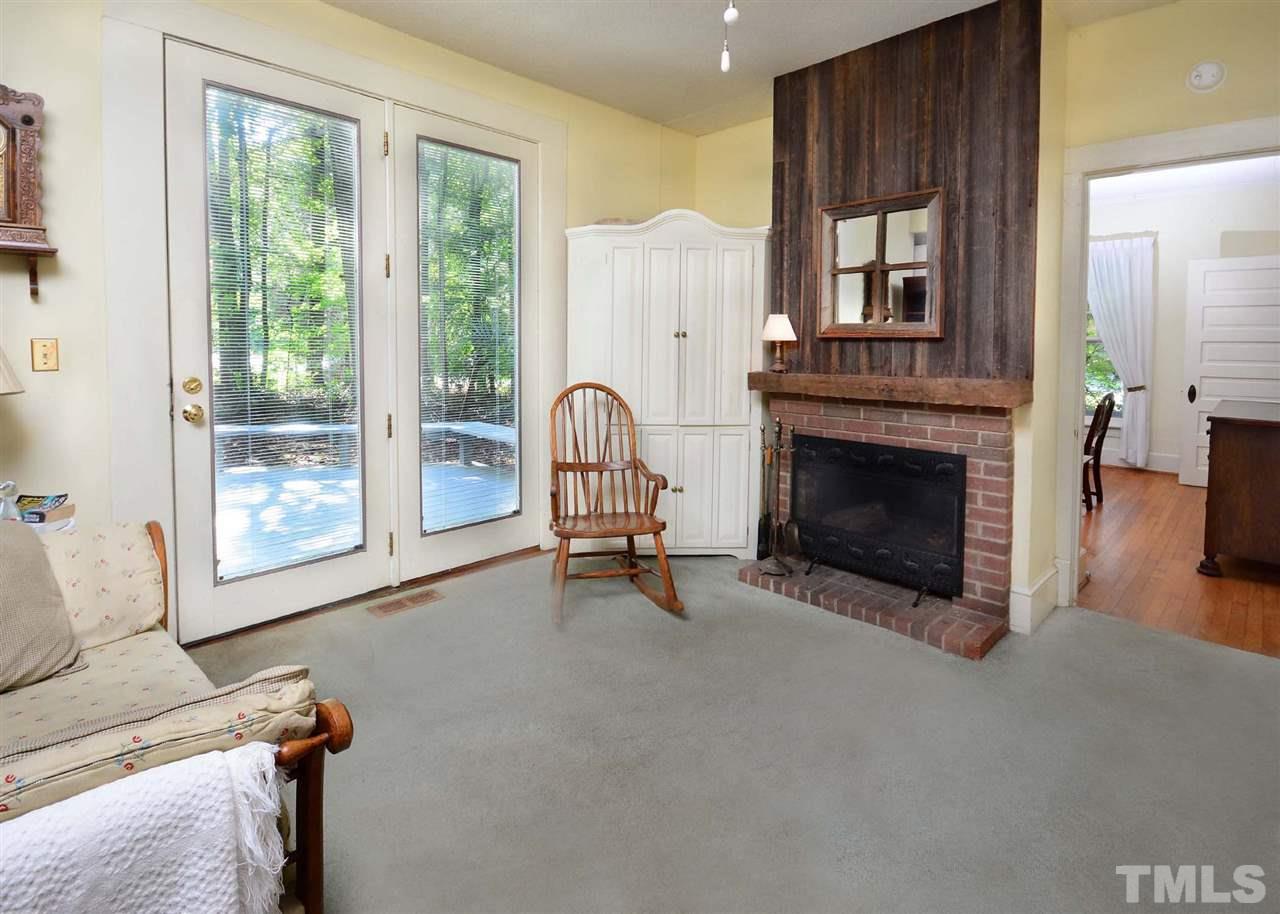 2114 Bahama Road Bahama, NC 27503 - Photo 14 of 21 a living room with furniture a fireplace and a floor to ceiling window