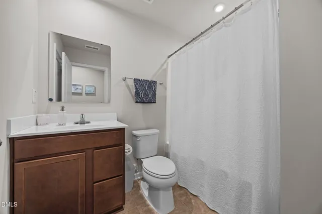 a bathroom with a toilet a sink a mirror and a shower