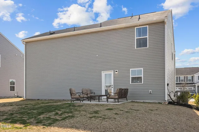 a backyard of a house with table and chairs