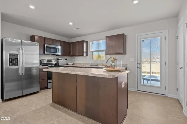 a kitchen with stainless steel appliances granite countertop a refrigerator sink and cabinets