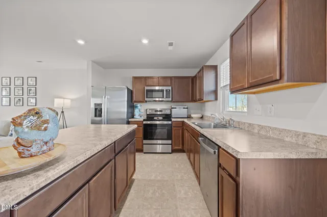a kitchen with stainless steel appliances granite countertop a sink stove and refrigerator