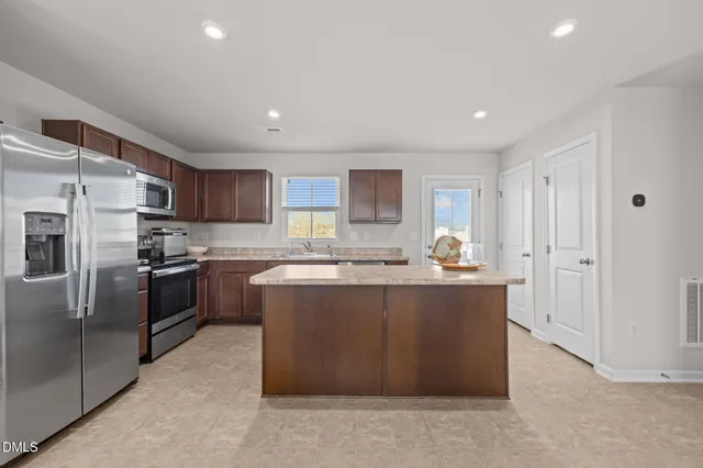 a large kitchen with stainless steel appliances lots of counter space and a sink