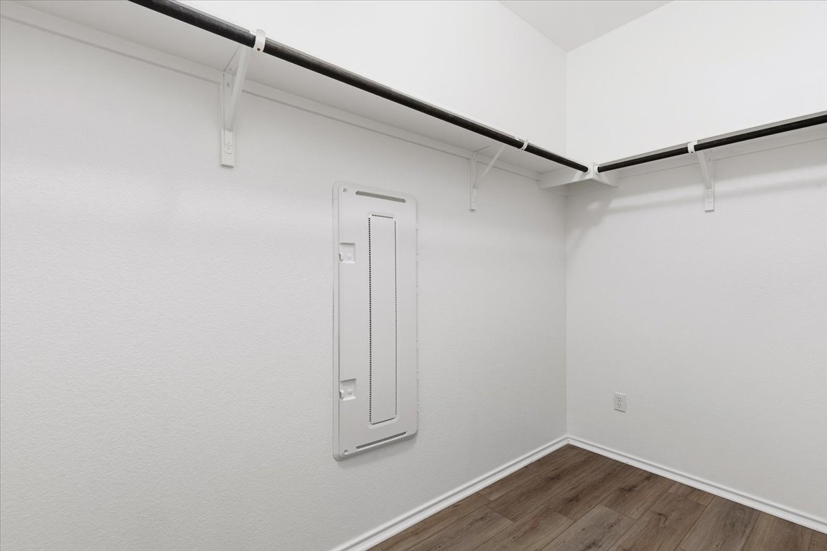 101 Rowdy Yates Way Jarrell, TX 76537 - Photo 20 of 32 Walk-in closet featuring wood-finish flooring, white walls, and built-in clothes rods with shelving