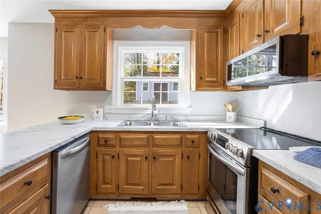 a kitchen with stainless steel appliances granite countertop a sink and a stove