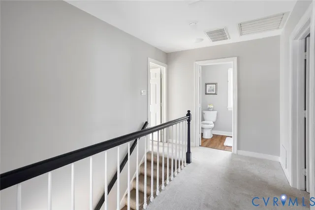 a view of a hallway with a livingroom and stairs