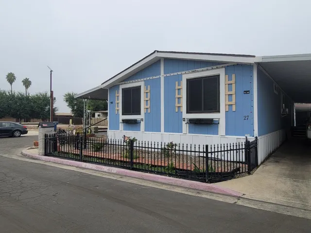 a view of a house with a balcony and wooden fence