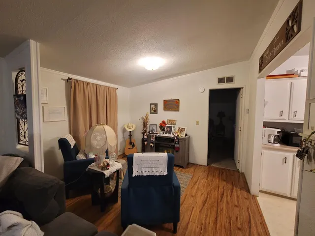 a living room with furniture and a refrigerator