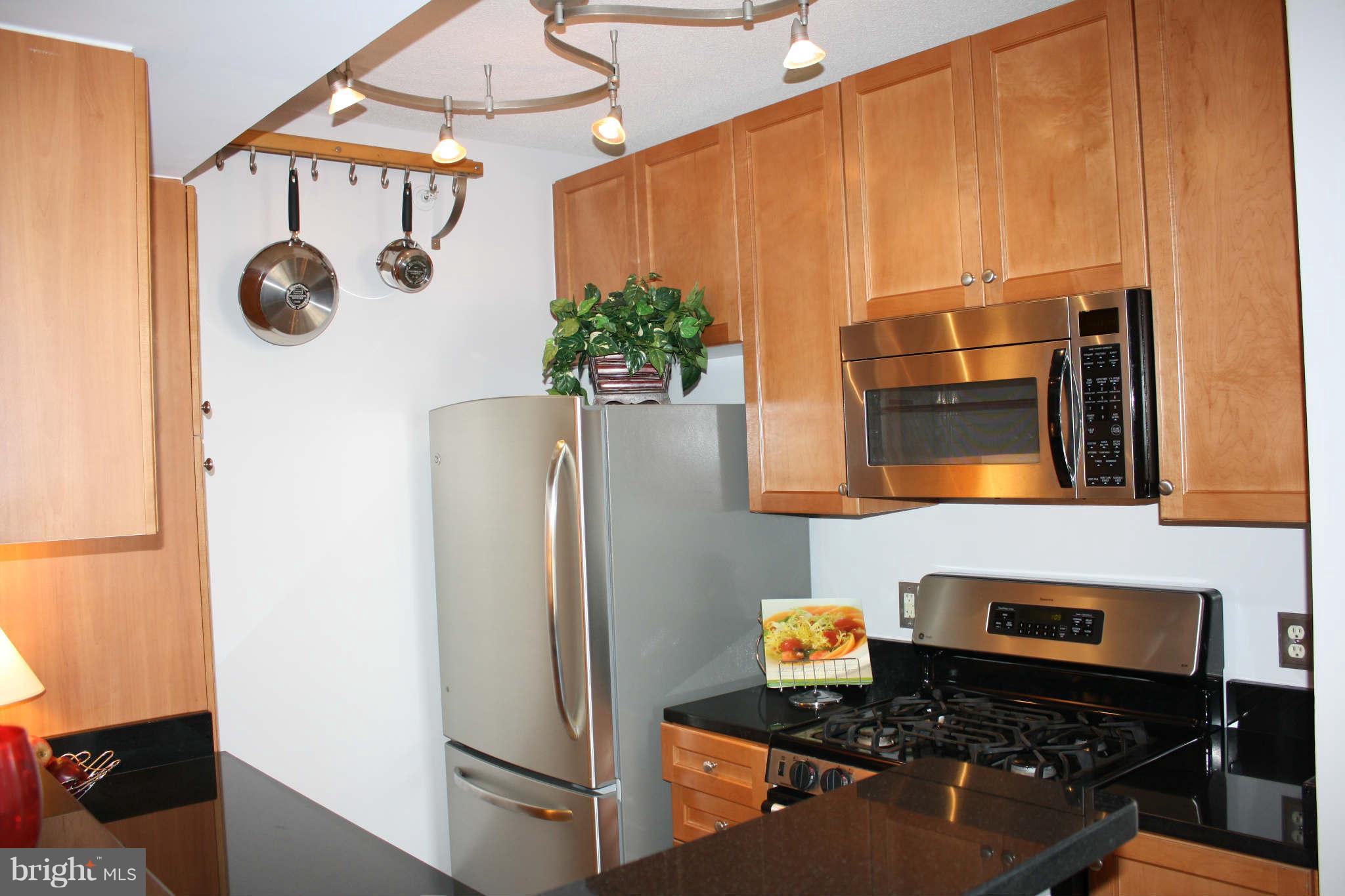 851 North Glebe Road, Unit 912 Arlington, VA 22203 - Photo 4 of 21 a kitchen with stainless steel appliances granite countertop a refrigerator and a stove